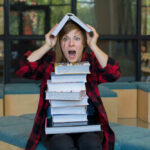 Court Slaps Down DeSantis’ Classroom Crackdown Person balancing books on head, looking surprised.