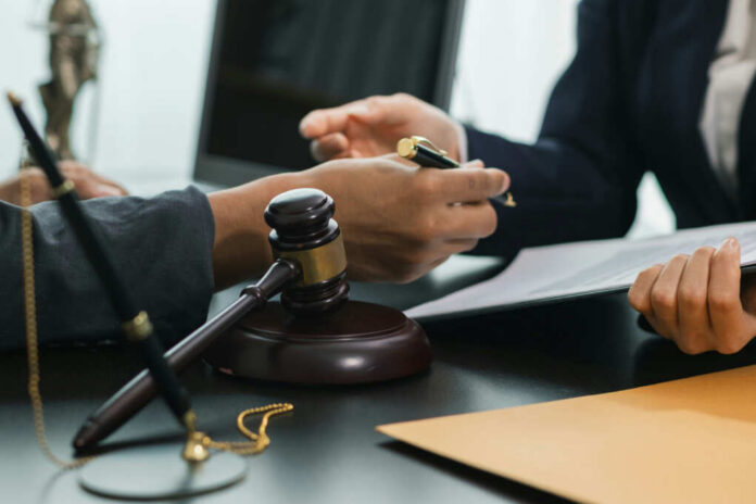 legal-counsel2486281457jpg Hands of professionals discussing documents beside a judge's gavel