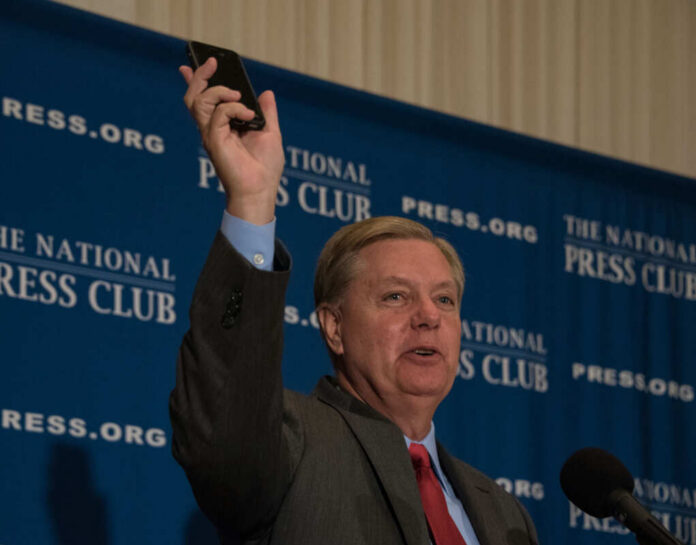 lindsey-graham315606863jpg Man holding phone at National Press Club event