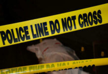 Police tape and covered figure at crime scene