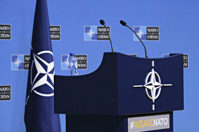 nato283194314 NATO podium with flags and microphones.