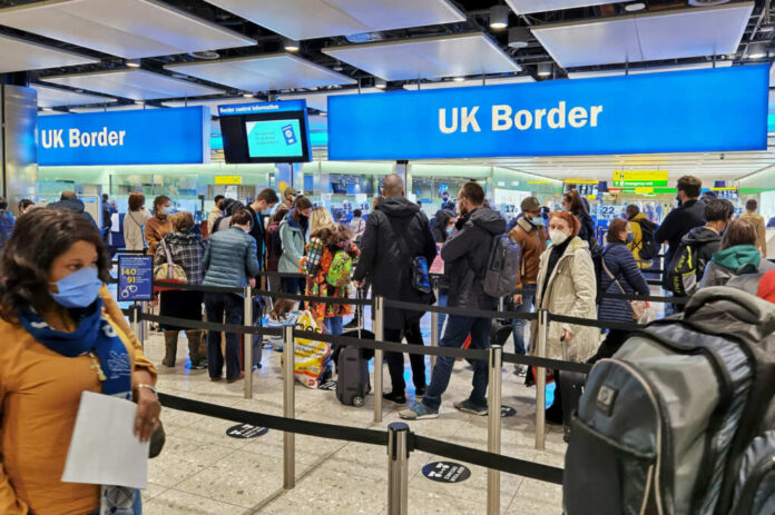 Travelers queue at UK border control in an airport
