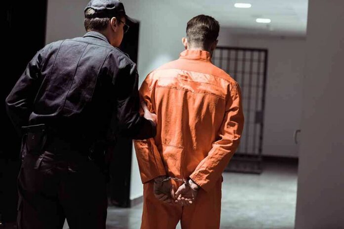 Police officer escorting handcuffed inmate in orange jumpsuit