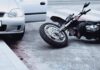 Vigilante Hunt Ends In Murder Motorcycle lying on the street beside a car with an open door