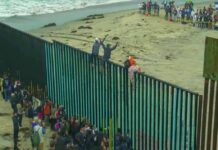 Ceuta Chaos Ignites Europe-Wide Fight People climbing a tall beachside border fence