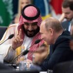 Two delegates converse at an international summit table