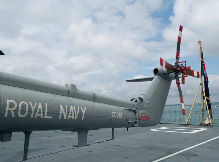 Royal,Navy,Helicopter,On,Ship,Deck Military helicopter on a naval deck with a cloudy sky