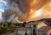 Suburban house under towering wildfire smoke plume
