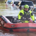 Helicopter Drama, Deadly Missed Warnings Rescue worker in an inflatable boat during urban flooding
