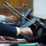 Army Axes Free Disability Lawyers Person pressing a button on a conference microphone panel