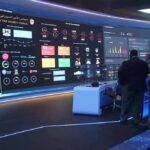 cybersecurity operations room with large data dashboards and people discussing