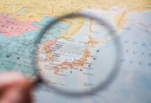 A magnifying glass focusing on a map of Japan