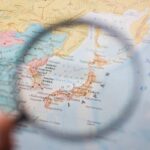 Cascade Chaos: Three Threats Converge A magnifying glass focusing on a map of Japan