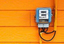 ROE Games: Households Get Squeezed Electric meter on bright orange wooden wall