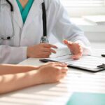 Deadly Cancer Hides In Plain Sight Doctor discusses medical notes with patient at a desk