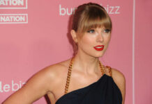 Woman with bangs in black dress on pink backdrop