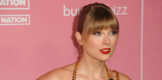 Woman with bangs in black dress on pink backdrop