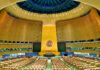 United Nations General Assembly hall with empty seats and golden backdrop