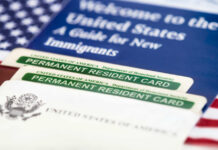 Dallas Fed Twist: ‘Invasion’ Narrative Cracks U.S. permanent resident cards with immigration guide and flag