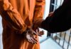 Garfield County Stunner: Five Felonies Prisoner in orange jumpsuit handcuffed by officer