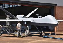 Iran’s Trophy Parade Masks A Bigger Play Military drone being serviced by ground crew outside a hangar