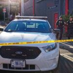Police car behind yellow caution tape on a city street