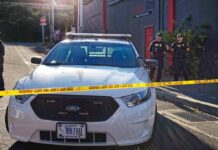 Police car behind yellow caution tape on a city street