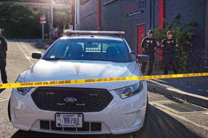 shutterstock_1143336623-1 Police car behind yellow caution tape on a city street