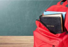 Bible Fight Erupts Over Health Care Red backpack with books on a classroom desk