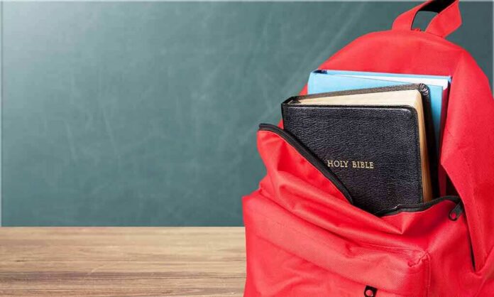 Red backpack with books on a classroom desk