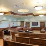 Plea Deal Silences Miami Murder Bombshell Empty courtroom with wooden benches and judge's bench