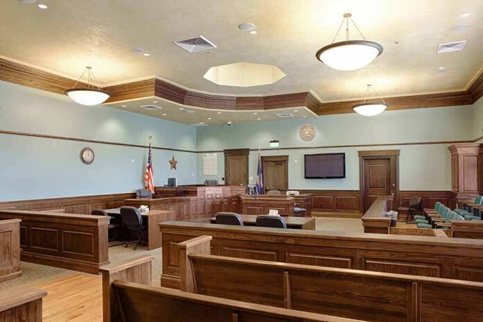 shutterstock_1349439551-1 Empty courtroom with wooden benches and judge's bench