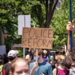 Abolish Prisons? No Plan for Rapists Protesters holding signs and wearing masks at an outdoor rally