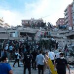 Rescue workers and civilians on collapsed building after earthquake