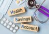 Public-Health Memory Meets Modern Risk Health savings account blocks with stethoscope and pills