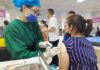 Censorship Bomb Lands In Vaccine Clash Healthcare worker giving a vaccine to a woman in a clinic