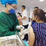Censorship Bomb Lands In Vaccine Clash Healthcare worker giving a vaccine to a woman in a clinic