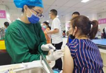 Healthcare worker giving a vaccine to a woman in a clinic