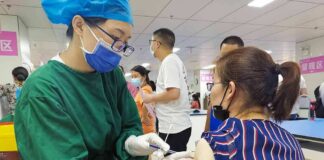 Healthcare worker giving a vaccine to a woman in a clinic