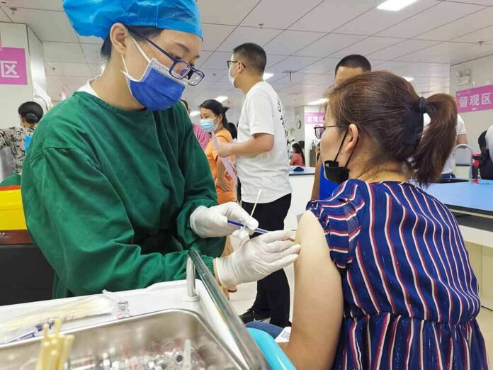 shutterstock_1989994547-1 Healthcare worker giving a vaccine to a woman in a clinic