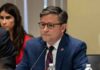 Co-President Claim Sparks Washington Jitters man in a blue suit speaking into a microphone at a meeting