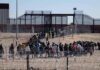 Abbey Gate Accounts Clash Over Preventable Tragedy Crowd of people lining up near a border fence with barbed wire