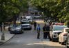 Michigan Rampage: Six Dead, Manhunt Ends Police officers secure a residential street with patrol cars and yellow tape
