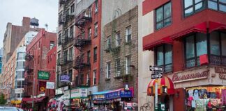 City street with brick buildings, fire escapes, and busy storefronts