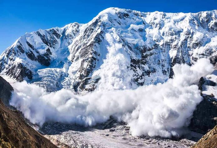 shutterstock_491923291-7 Snow avalanche sweeping down a rugged mountain