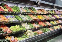 Taco Bell Lettuce Tied To Massive Illness Grocery store produce aisle with stacked fresh vegetables