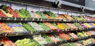 Grocery store produce aisle with stacked fresh vegetables