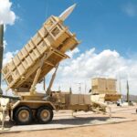 Patriot missile defense system on display outdoors with various missiles in the background
