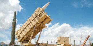 Patriot missile defense system on display outdoors with various missiles in the background