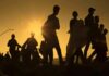 Silhouettes of people walking at sunset